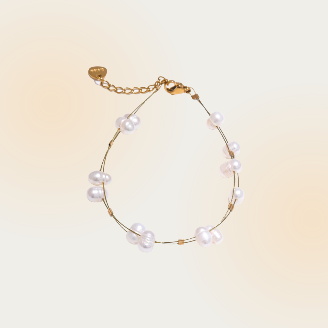 This image features a delicate gold bracelet adorned with lustrous white pearls. The pearls are spaced evenly along the chain, creating a refined and elegant accessory perfect for adding a touch of sophistication to any outfit.