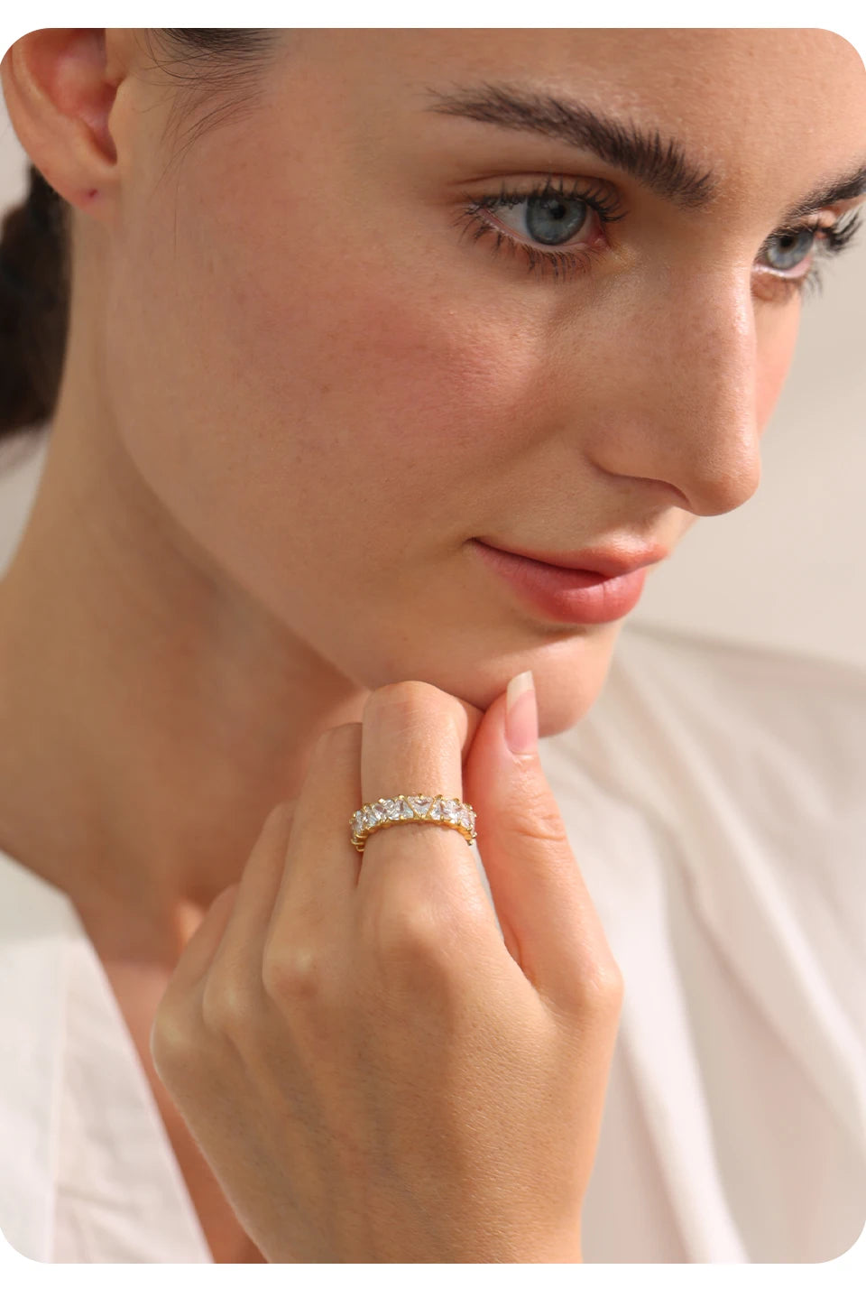 Close-up of a woman wearing a diamond ring on a plain background