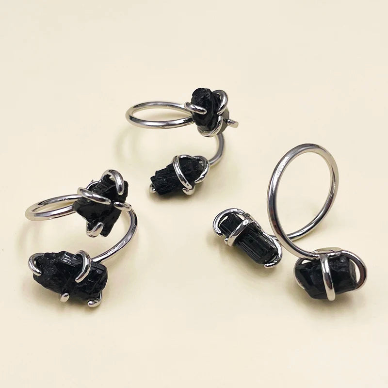 Silver ring with black gemstones on a beige background