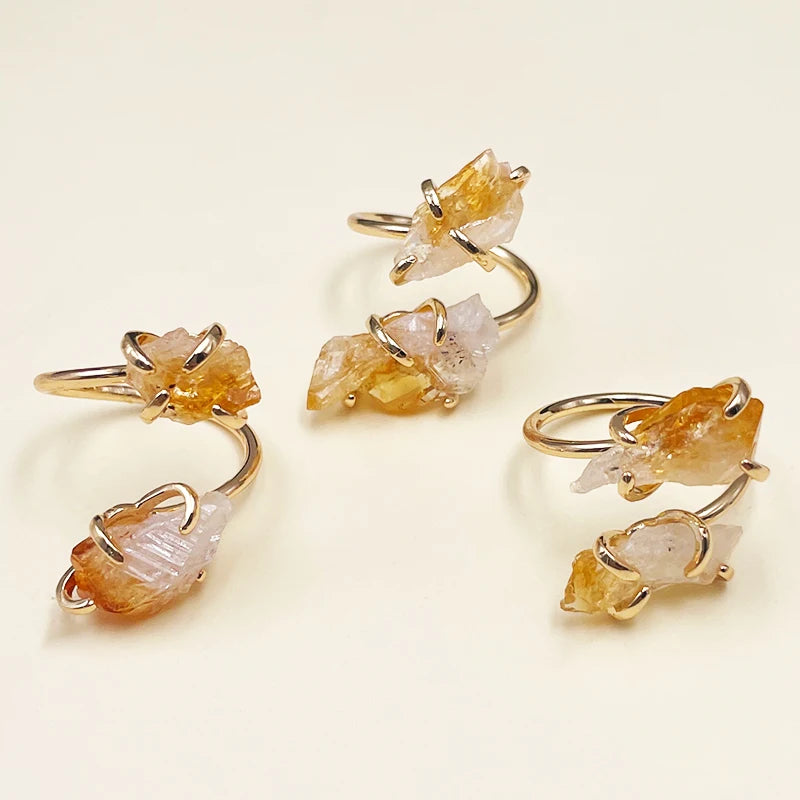 Set of gold rings with natural stone elements on a light beige background