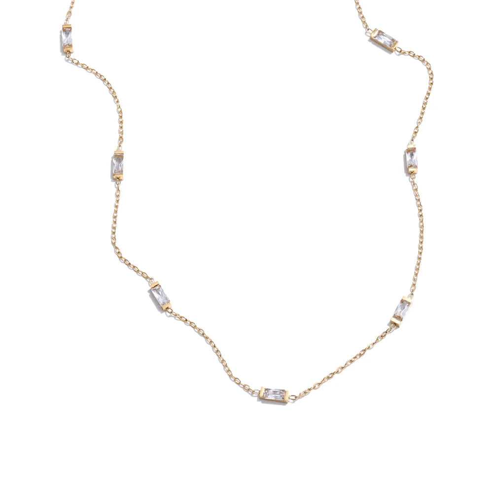 Gold necklace with embedded stones on a white background