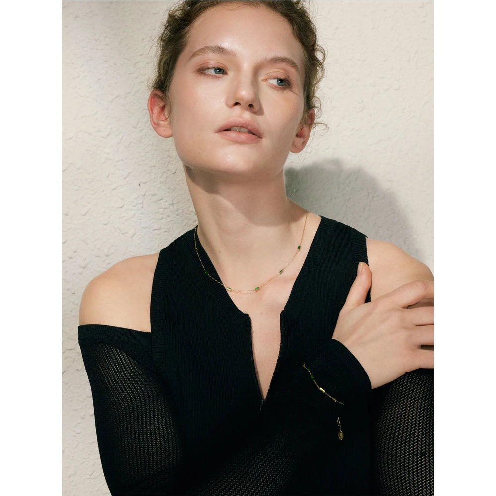 Woman wearing a black off-shoulder top against a neutral background