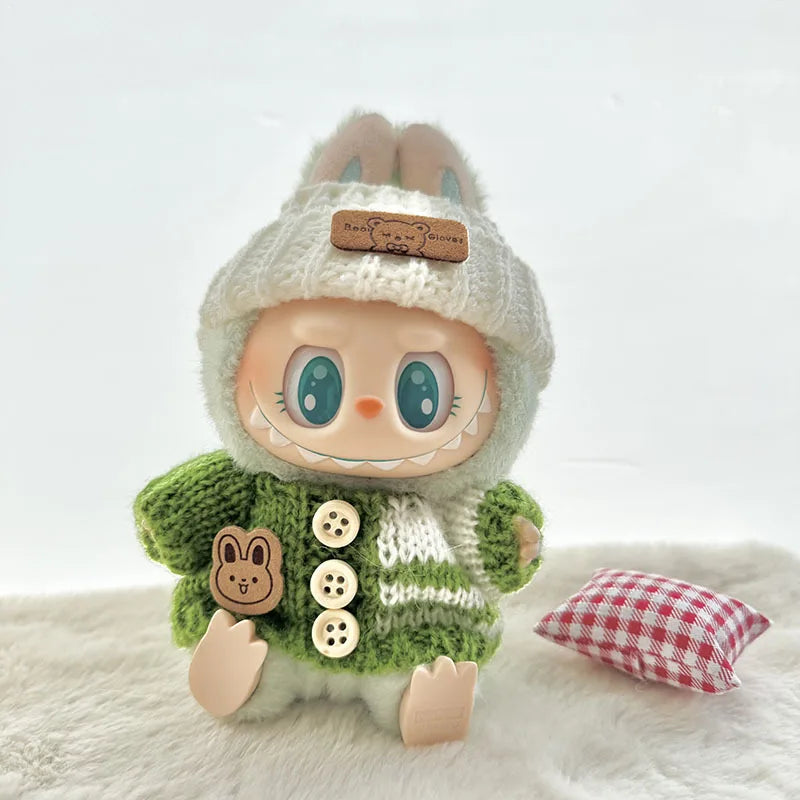 Stuffed labubu toy with a green sweater and white hat on a white background