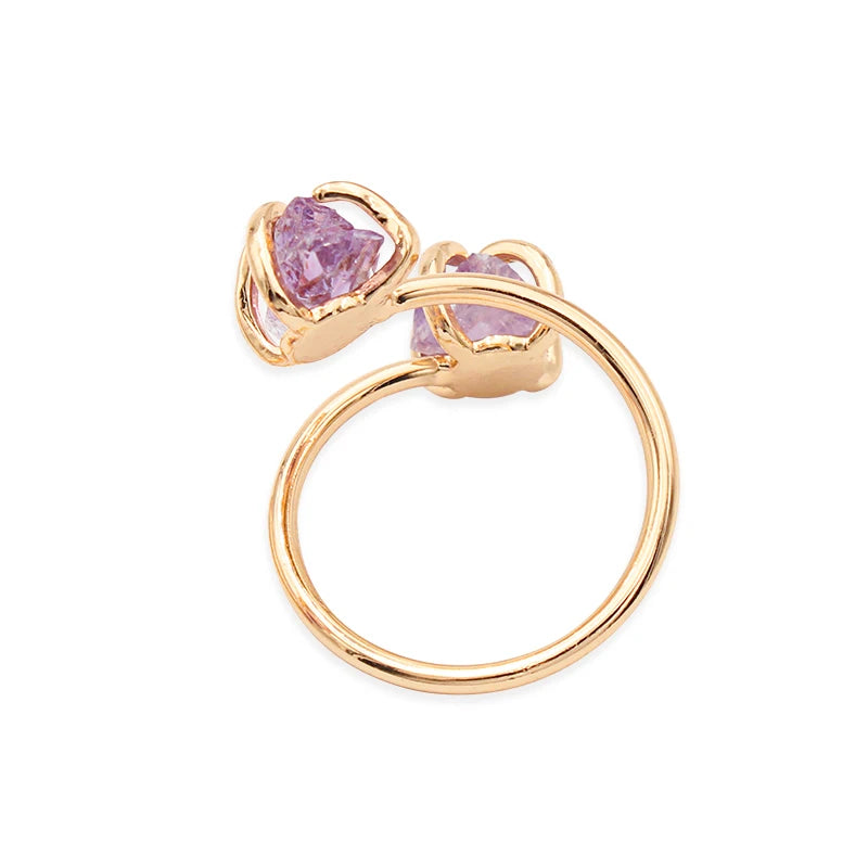 Gold ring with pink gemstones on a white background