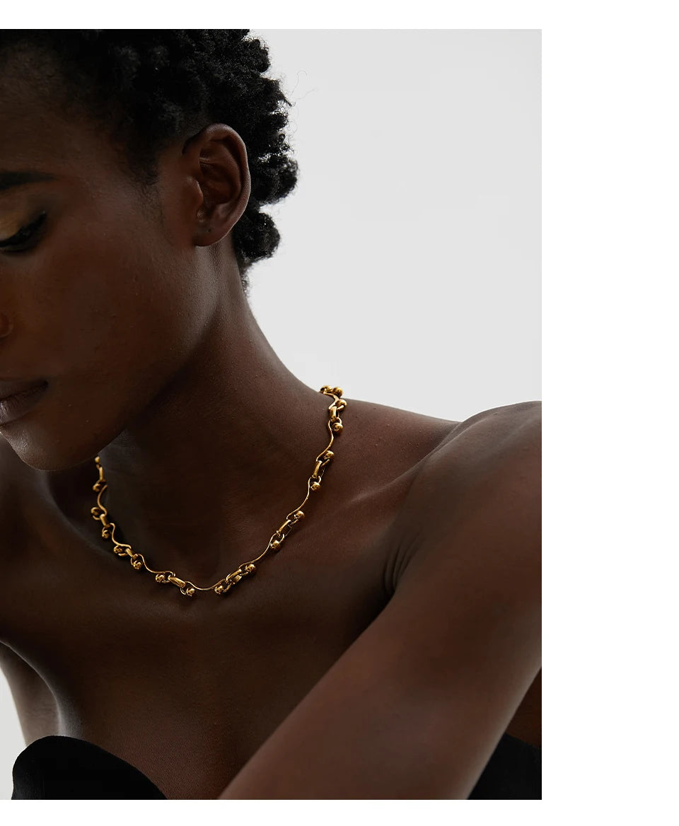 Gold chain necklace on a model against a neutral background