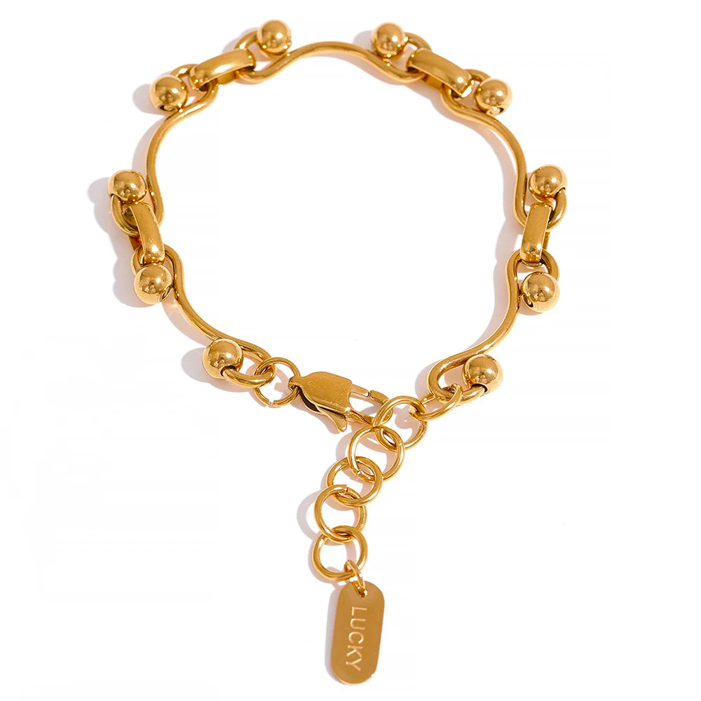 Gold bracelet with a 'Lucky' tag on a white background