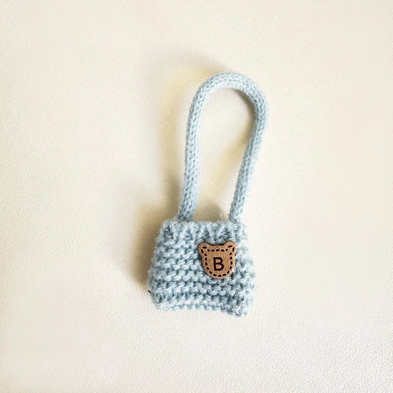 Blue knitted dog toy with a brown patch on a beige background