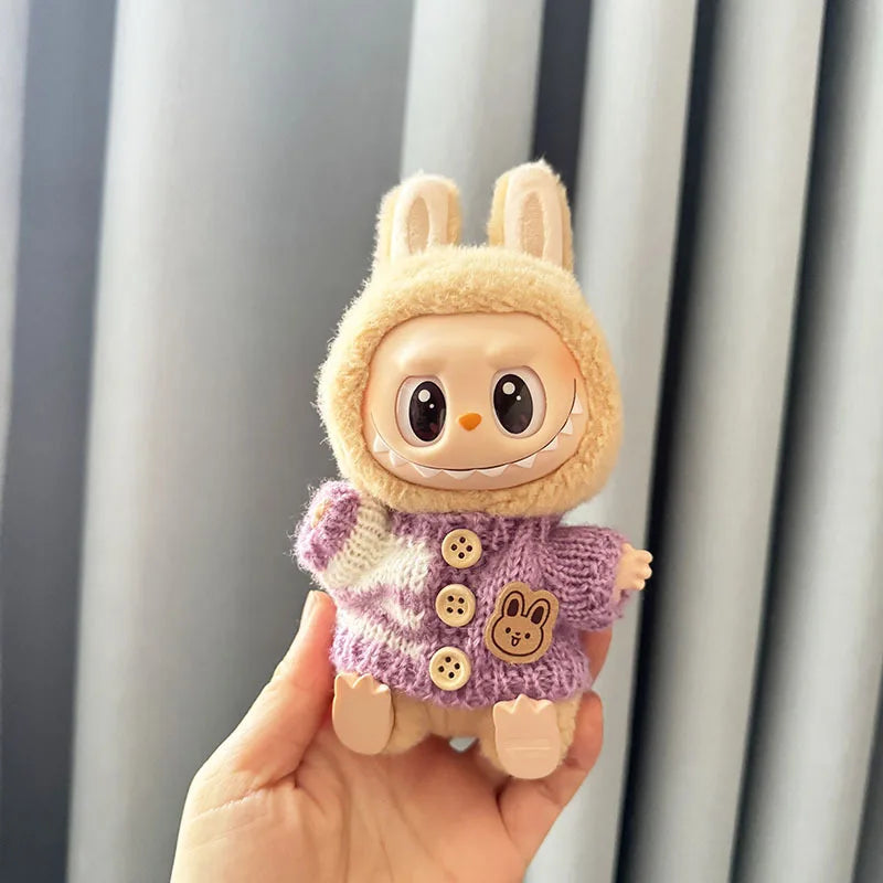 labubu toy figure of a character wearing a bunny costume with a purple sweater, held against a neutral background.