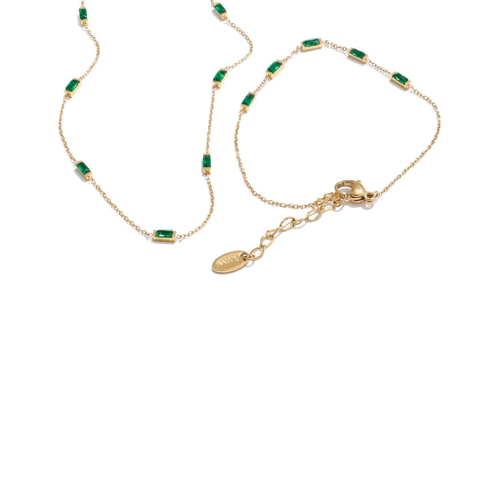 Gold necklace with green gemstones and a matching bracelet on a white background, featuring the brand 'Yi Fayu'.