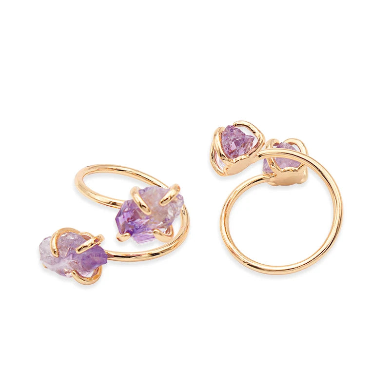 Gold rings with purple gemstones on a white background