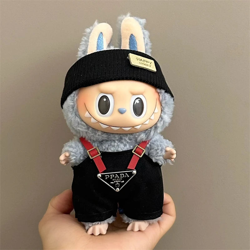 Labubu toy figure with a black headband and Prada outfit held in a hand against a plain background