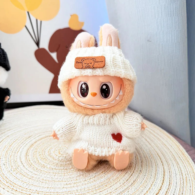 Plush labubu  toy with a white sweater and red heart on a textured surface