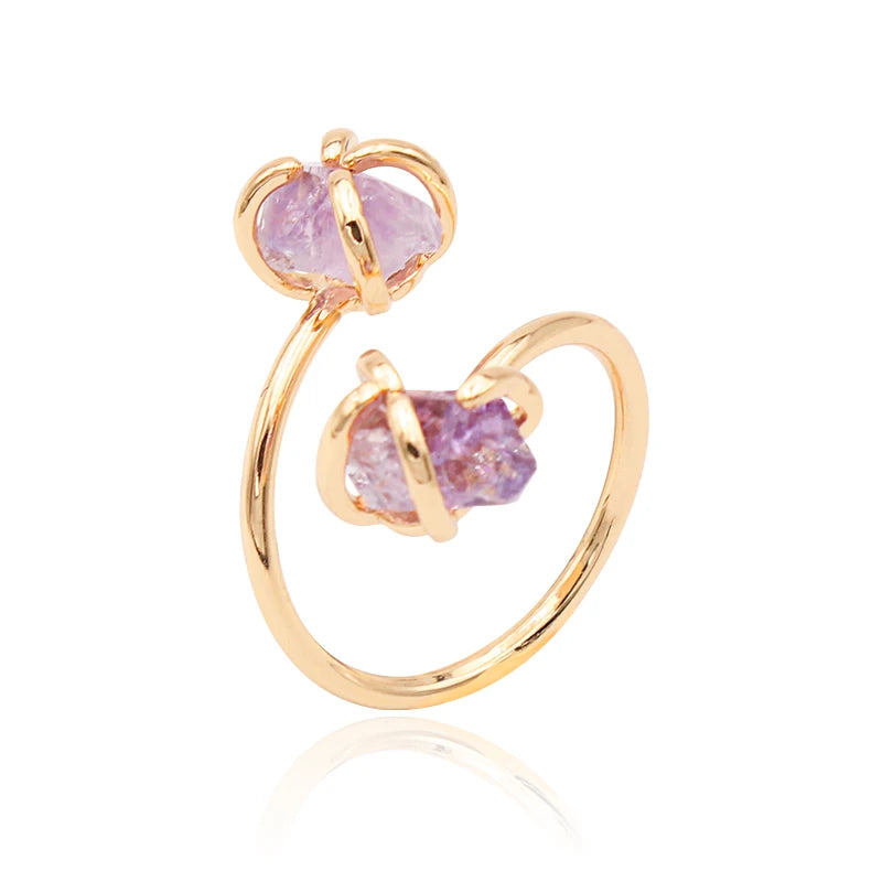 Gold ring with pink gemstones on a white background
